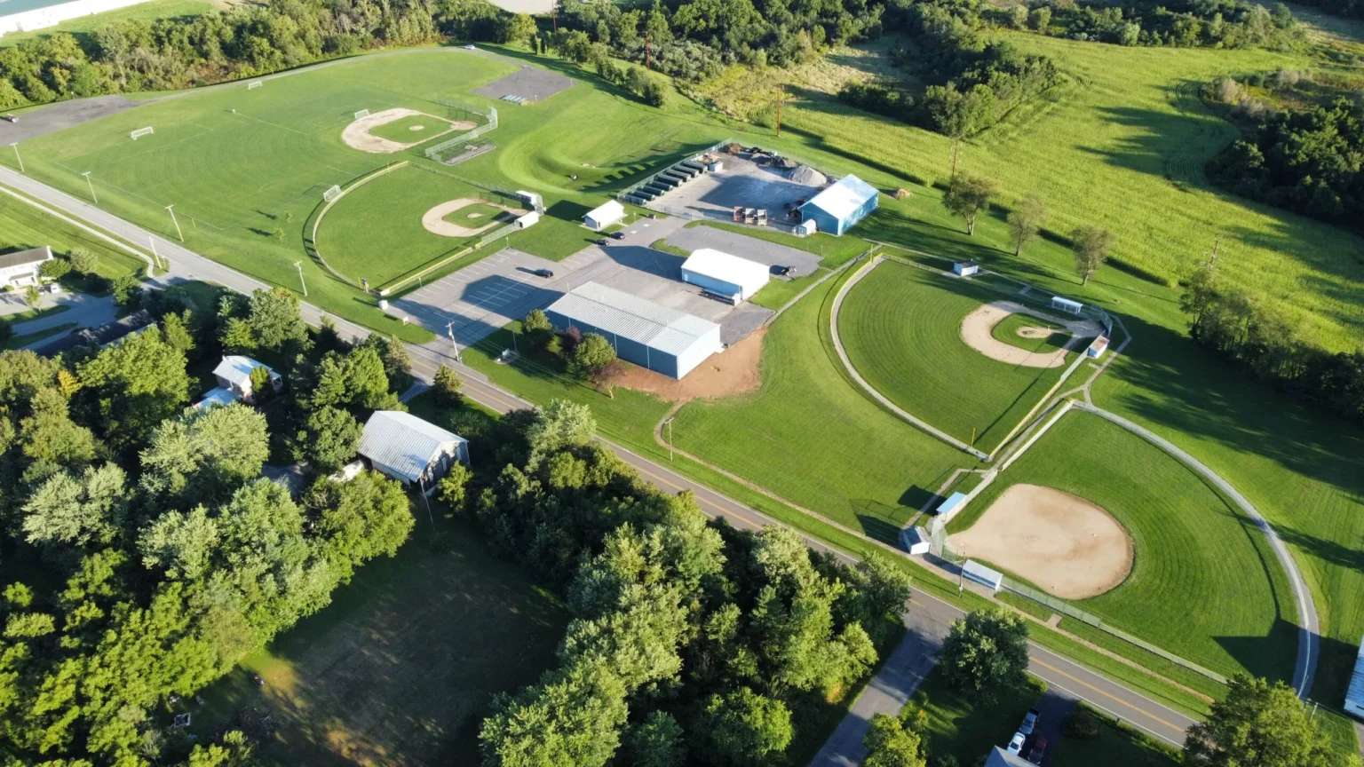 An aerial view of the Kelly Township athletic complex, featuring multiple baseball diamonds surrounded by a track, roads, and suburban buildings.