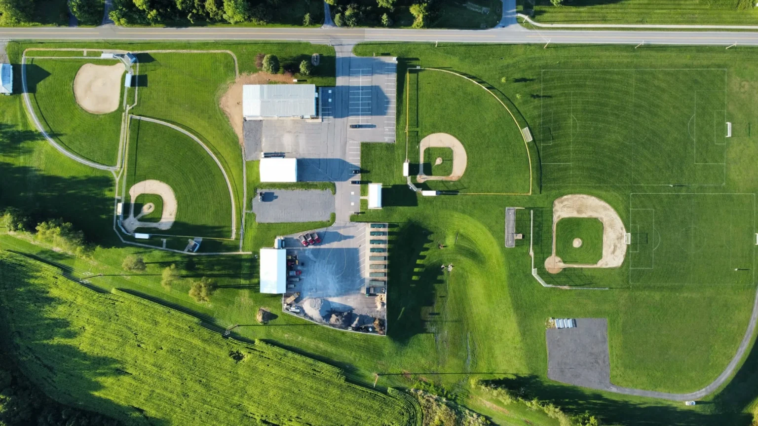 An aerial view of a large athletic complex with multiple baseball diamonds, bordered by a track, roads, and surrounding development, with "Kelly Township" visible in the context of the page title.